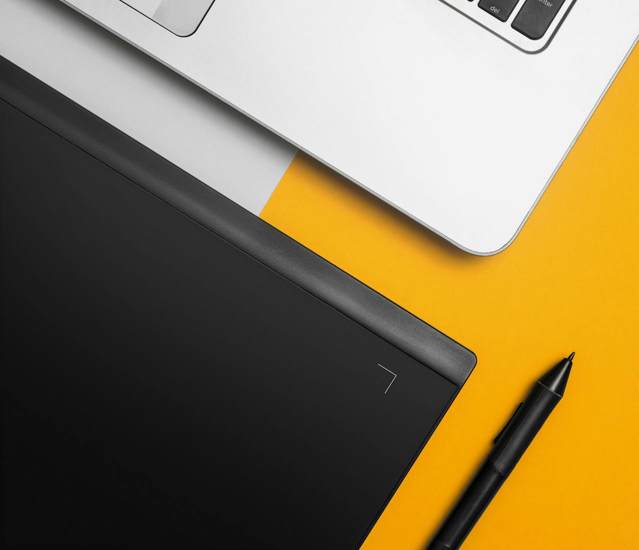 menu-01 Overhead view of a laptop and graphics tablet on a colorful desk setup.